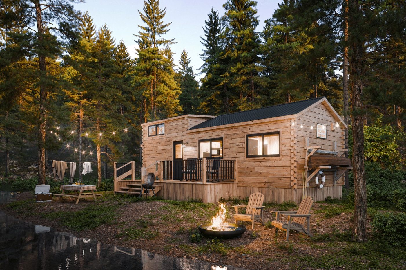 The Pinecrest log park model tiny home by Zook Cabins with a covered porch and a gable metal roof in the woods