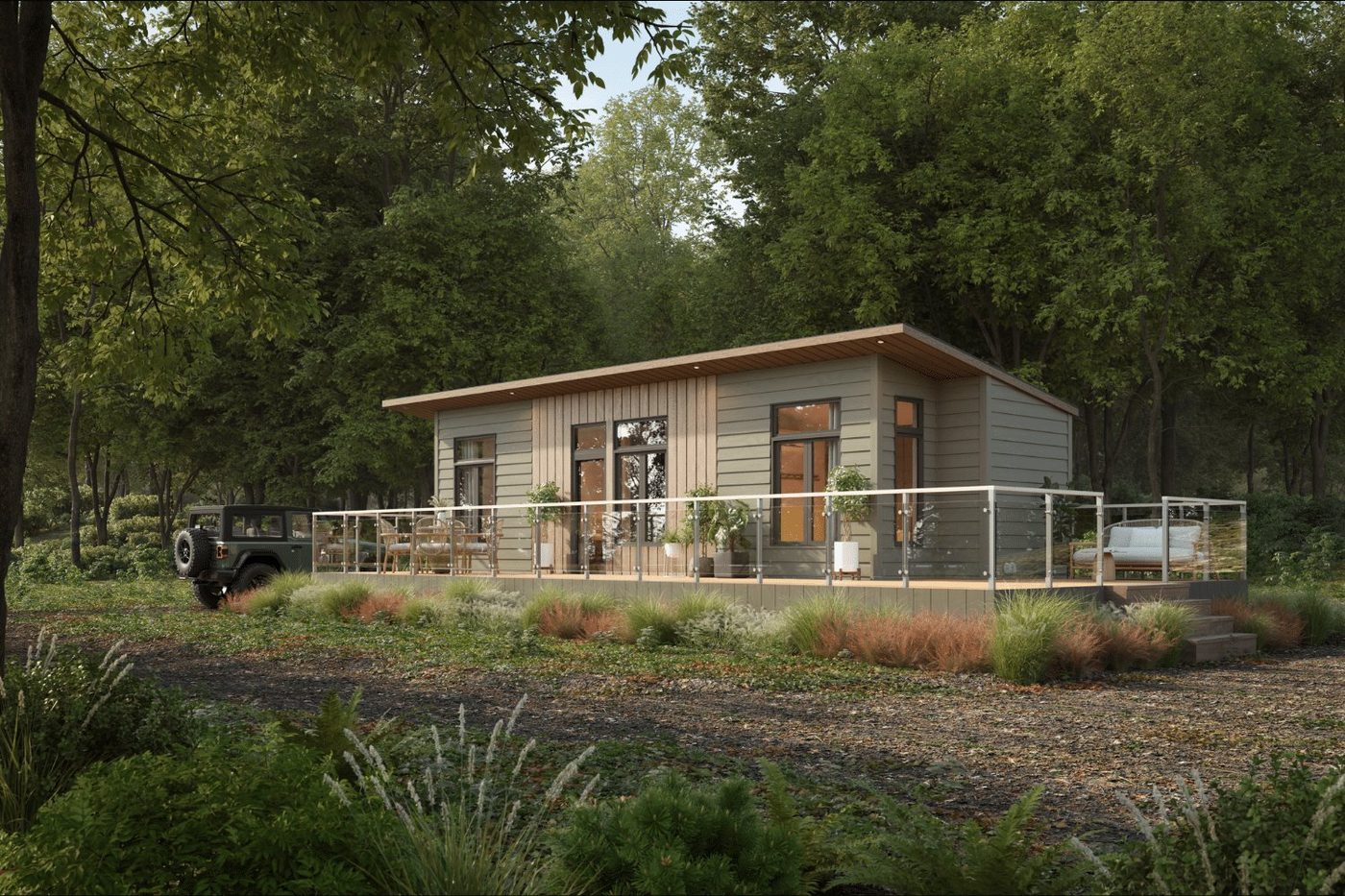 The Sonoma park model tiny home by Zook Cabins, a modern home with light sage lap siding, a flat overhanging roof, and a glass-railing wraparound deck in the woods